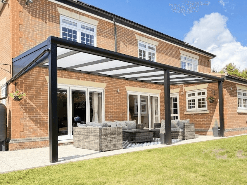 Sloped glass roof veranda with anthracite frame attached to a brick home